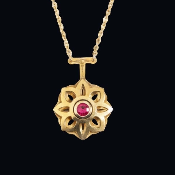Bedrock Rose gold Art Deco floral pendant necklace with a central ruby gemstone. Intricate openwork design.