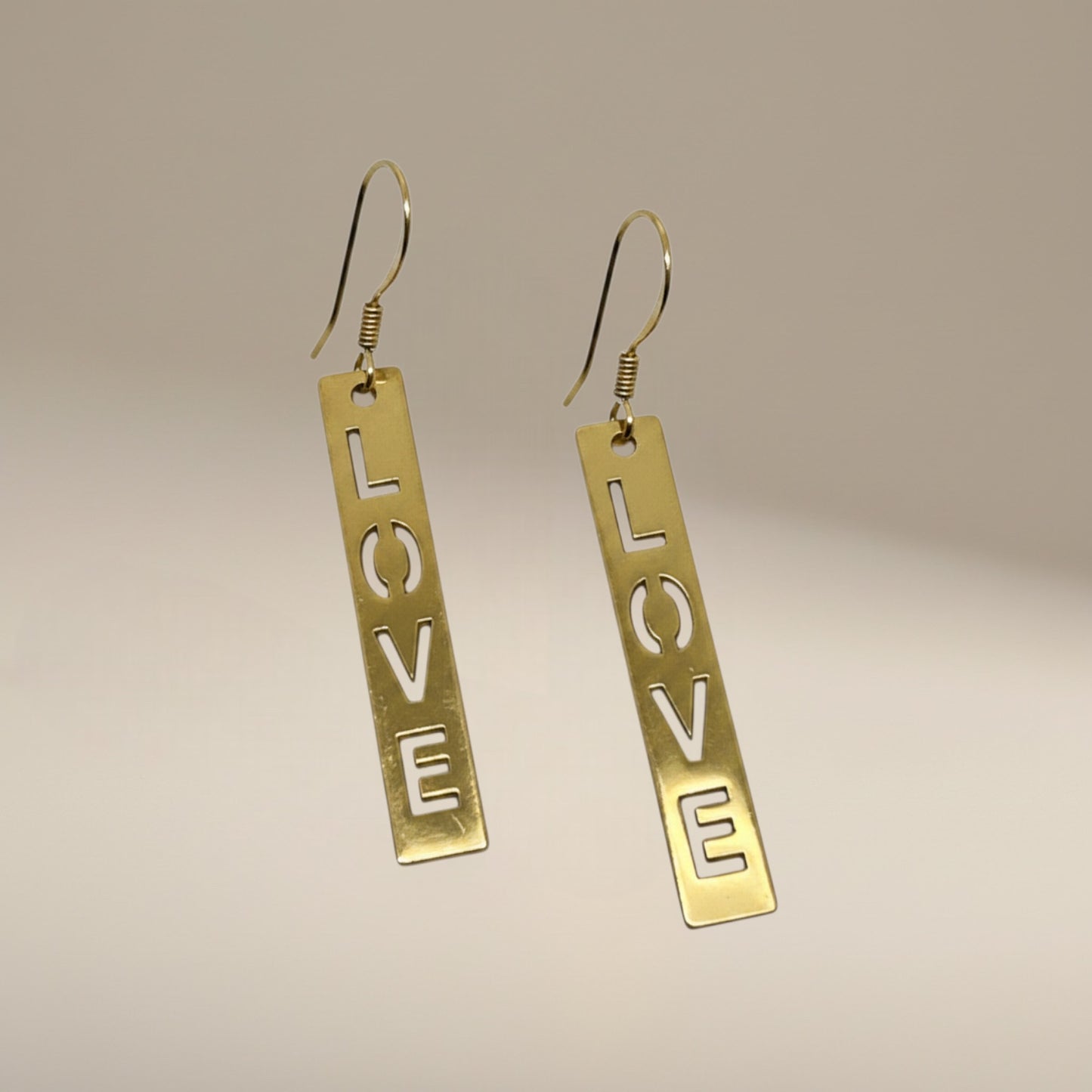 Bedrock Rose gold-plated dangling earrings with laser-cut 'LOVE' text. Surgical steel earwires.