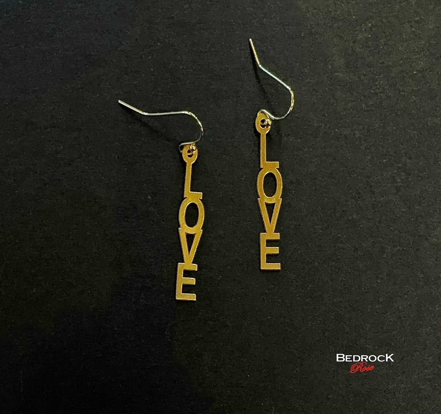 Bedrock Rose gold-plated dangling earrings with laser-cut out "Love" text. Surgical steel earwires.