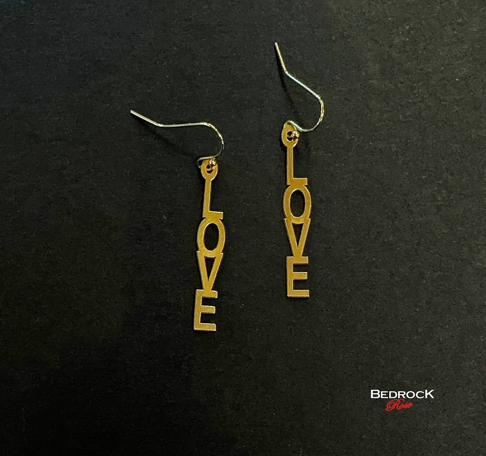 Bedrock Rose gold-plated dangling earrings with laser-cut out "Love" text. Surgical steel earwires.