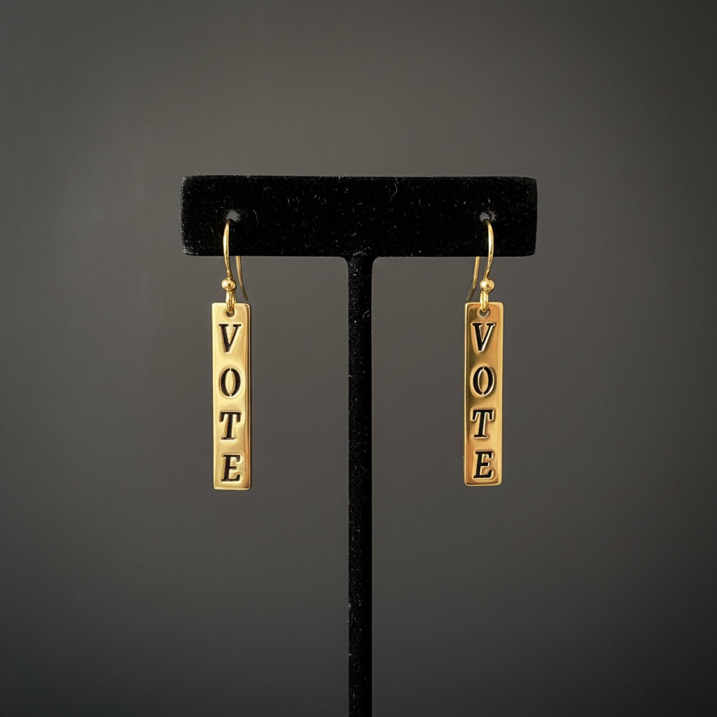 Bedrock Rose gold-plated dangling earrings with laser-cut "VOTE" text. Dangling bar earrings with hook closure.