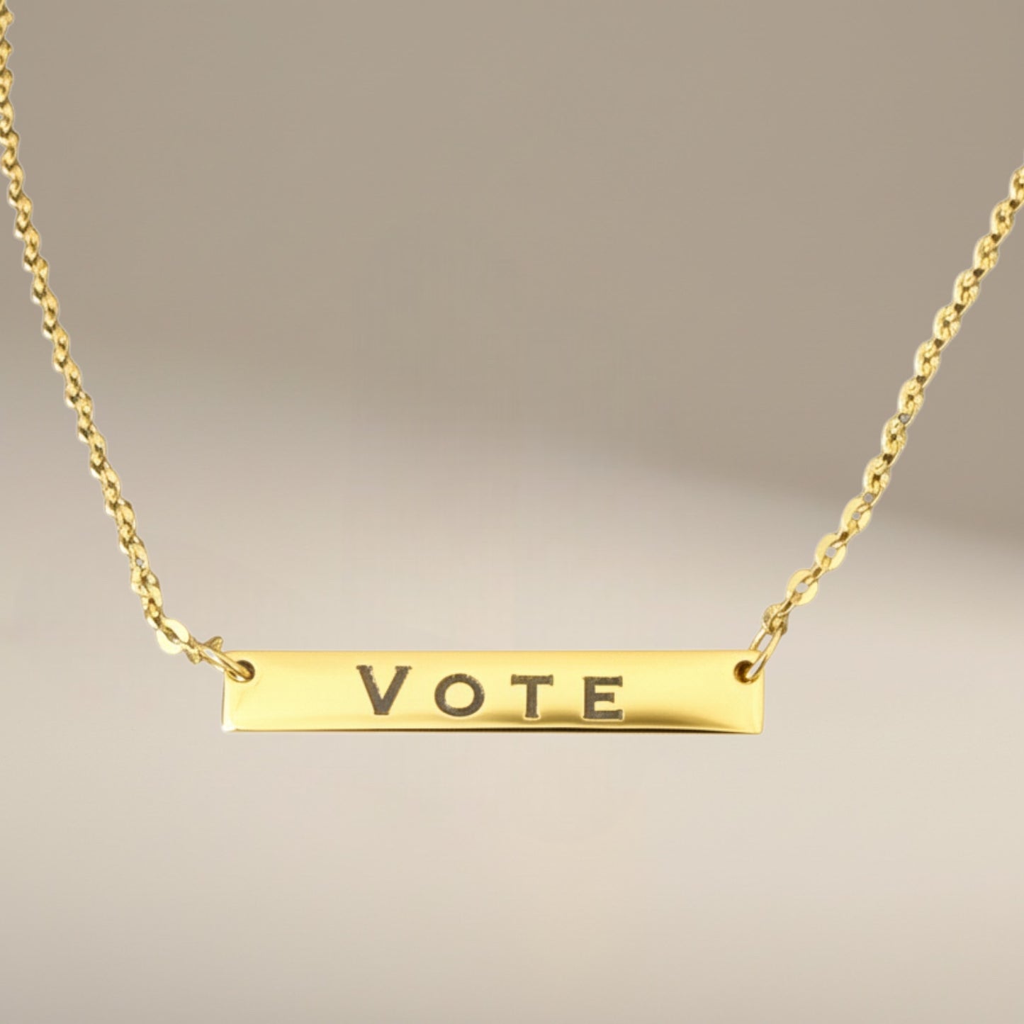 Bedrock Rose gold-plated stainless steel bar necklace with the word VOTE engraved. Features a delicate chain with an extender.