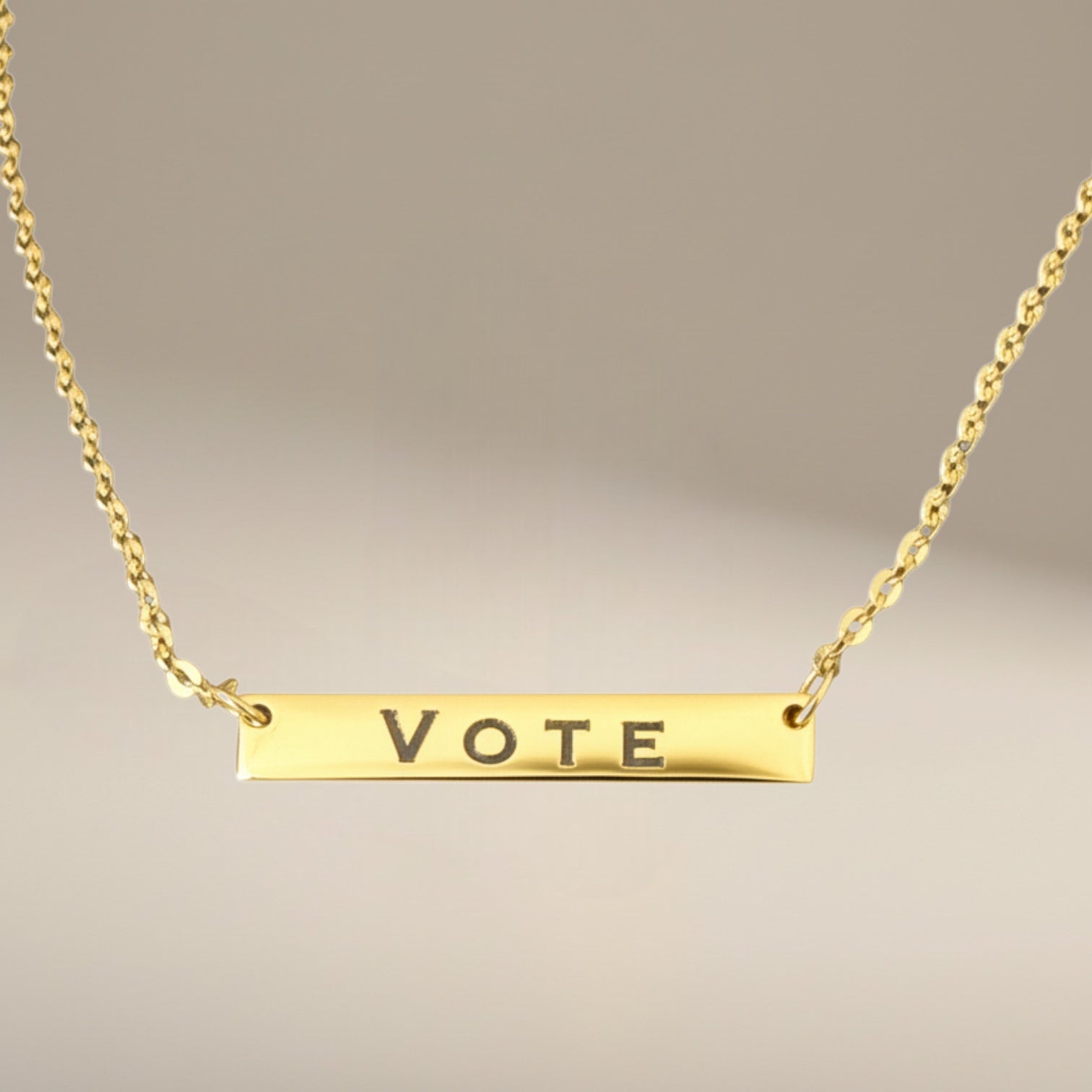 Bedrock Rose gold-plated stainless steel bar necklace with the word VOTE engraved. Features a delicate chain with an extender.