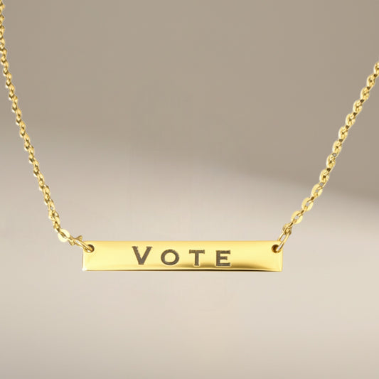 Bedrock Rose gold-plated stainless steel bar necklace with the word VOTE engraved. Features a delicate chain with an extender.