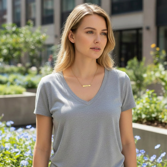 Bedrock Rose gold-plated stainless steel bar necklace with the word "Vote" engraved, worn by a woman.