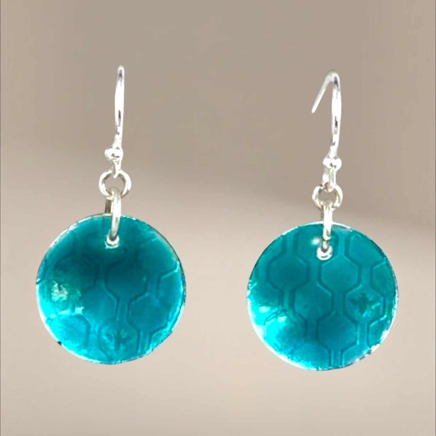Bedrock Rose transparent green circle dangle earrings with honeycomb pattern and silver hooks.