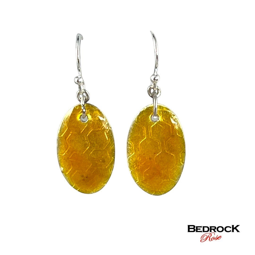 Bedrock Rose honey-colored oval earrings with honeycomb pattern, dangling from silver hooks.