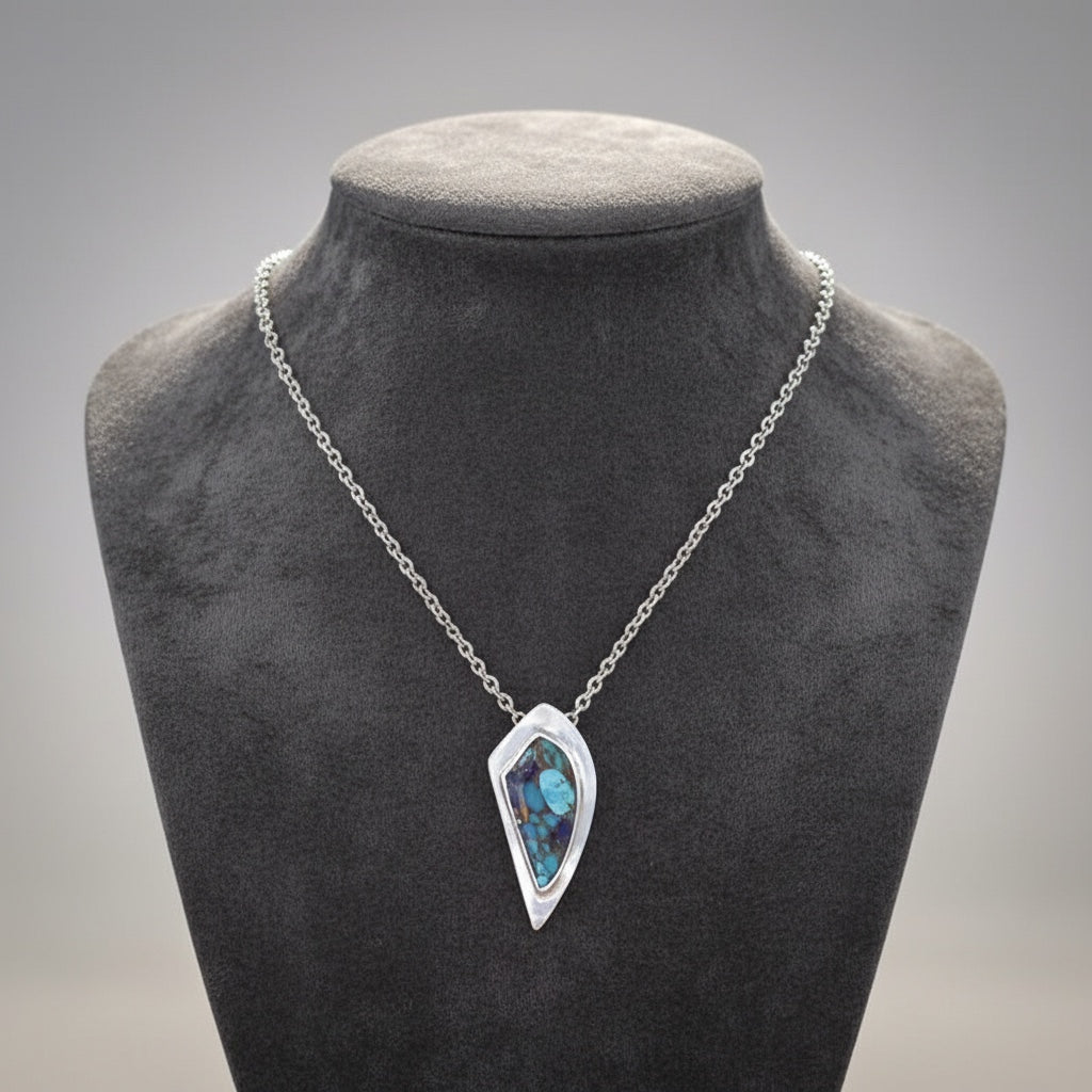 Bedrock Rose Kingman Turquoise and Lapis Lazuli pendant in bronze with a silver-tone chain. Geometric design with vibrant blue and green hues.
