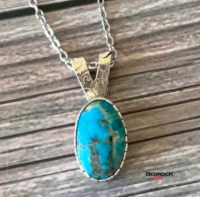 Bedrock Rose Kingman Turquoise pendant with silver bezel and chain. Oval blue-green stone.