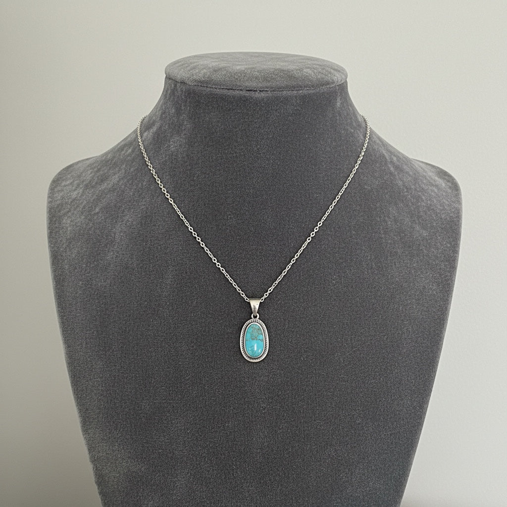 Woman wearing Bedrock Rose sterling silver pendant with oval Kingman turquoise gemstone and matching earrings.
