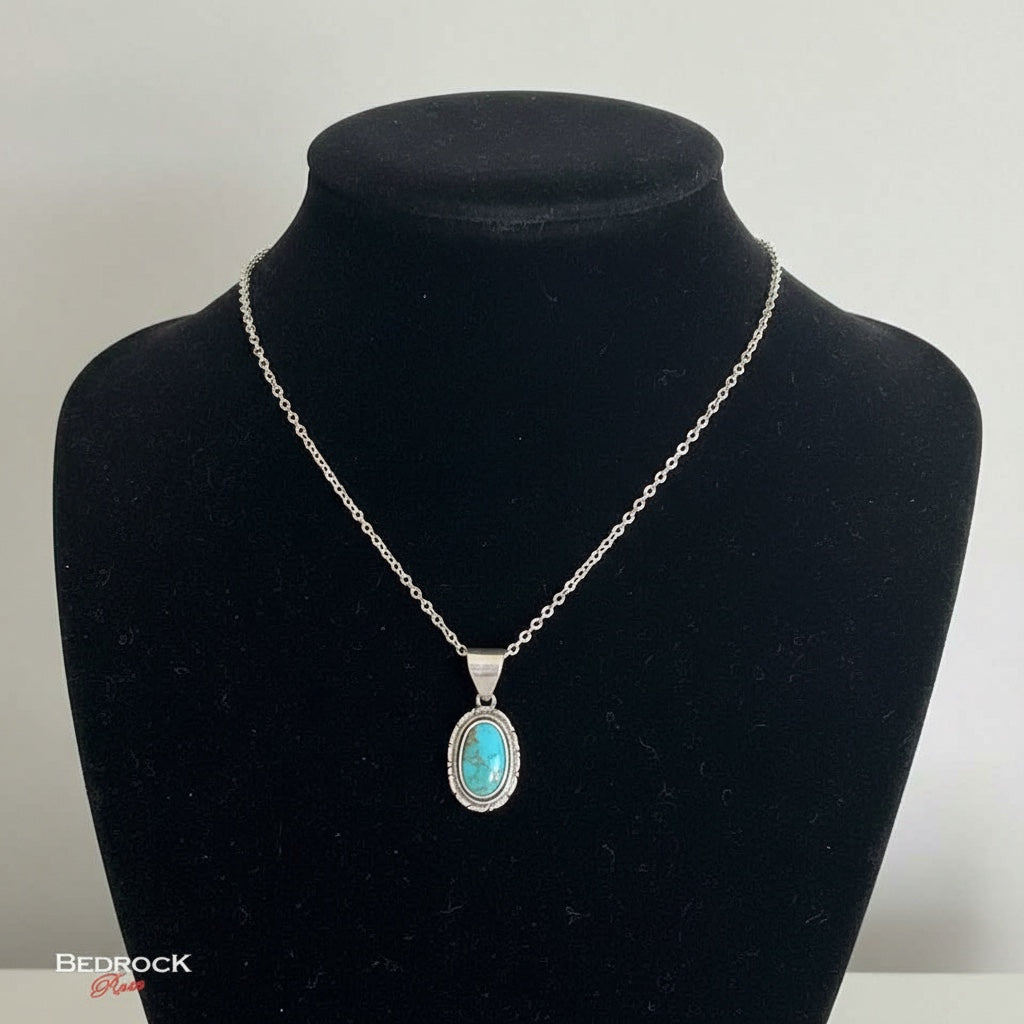 Bedrock Rose oval Kingman turquoise pendant in sterling silver with intricate detailing on a silver chain.