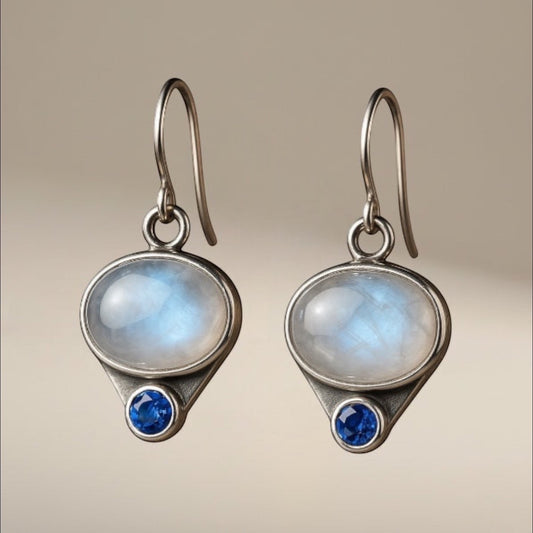 Bedrock Rose sterling silver dangling earrings with oval moonstones and blue simulated sapphires.