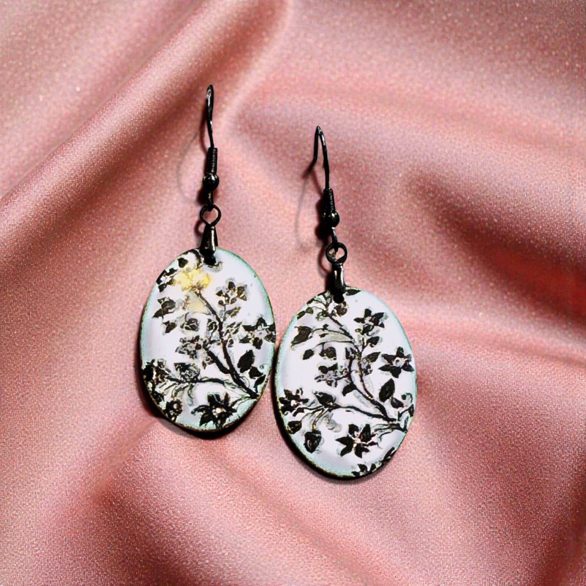 Bedrock Rose hand-enameled oval copper earrings with black floral design on white enamel.