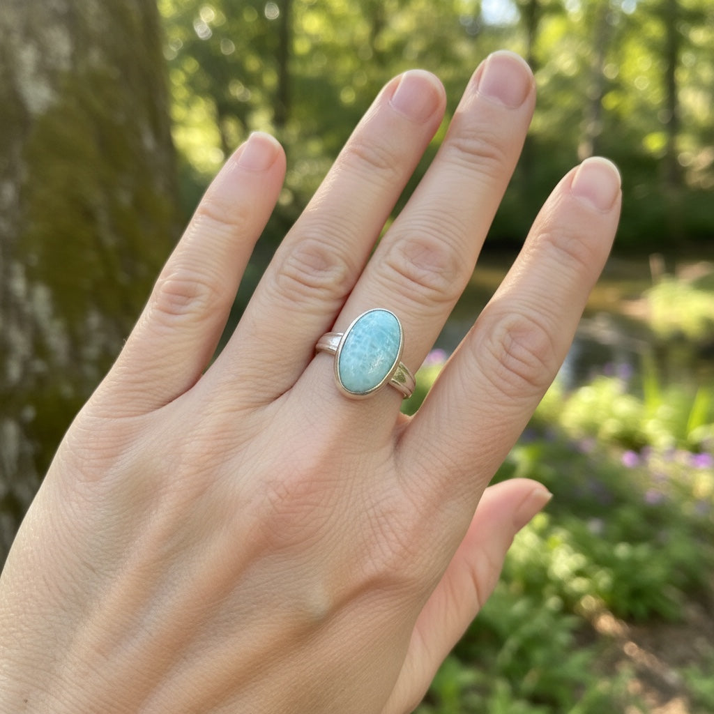 Bedrock Rose oval larimar ring with a silver band, featuring a light blue stone with white swirls.
