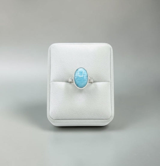 Bedrock Rose oval larimar ring with silver band, presented on a white jewelry stand.