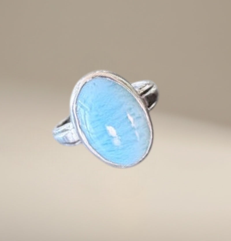 Bedrock Rose oval larimar ring with silver band. Light blue stone with white swirls.