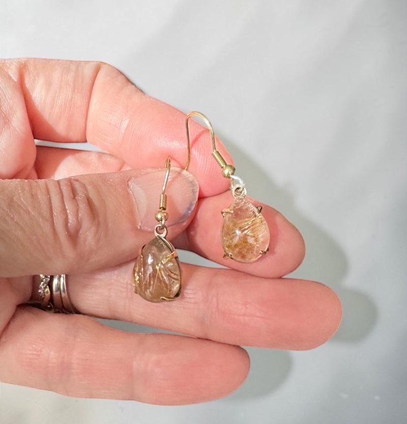 Bedrock Rose prong set pear rutilated quartz drop earrings with gold hooks and unique inclusions.