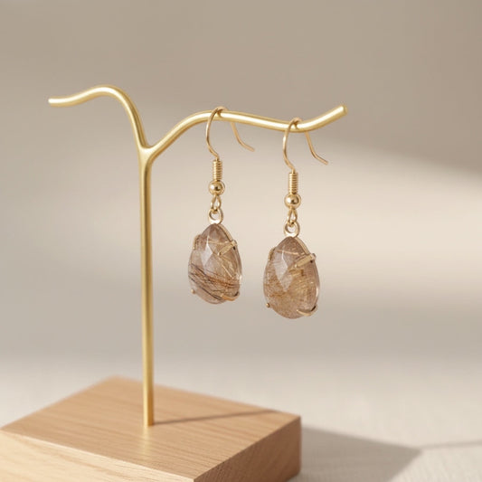 Bedrock Rose Prong Set Pear Rutilated Quartz Earrings with gold hooks and faceted teardrop stones.