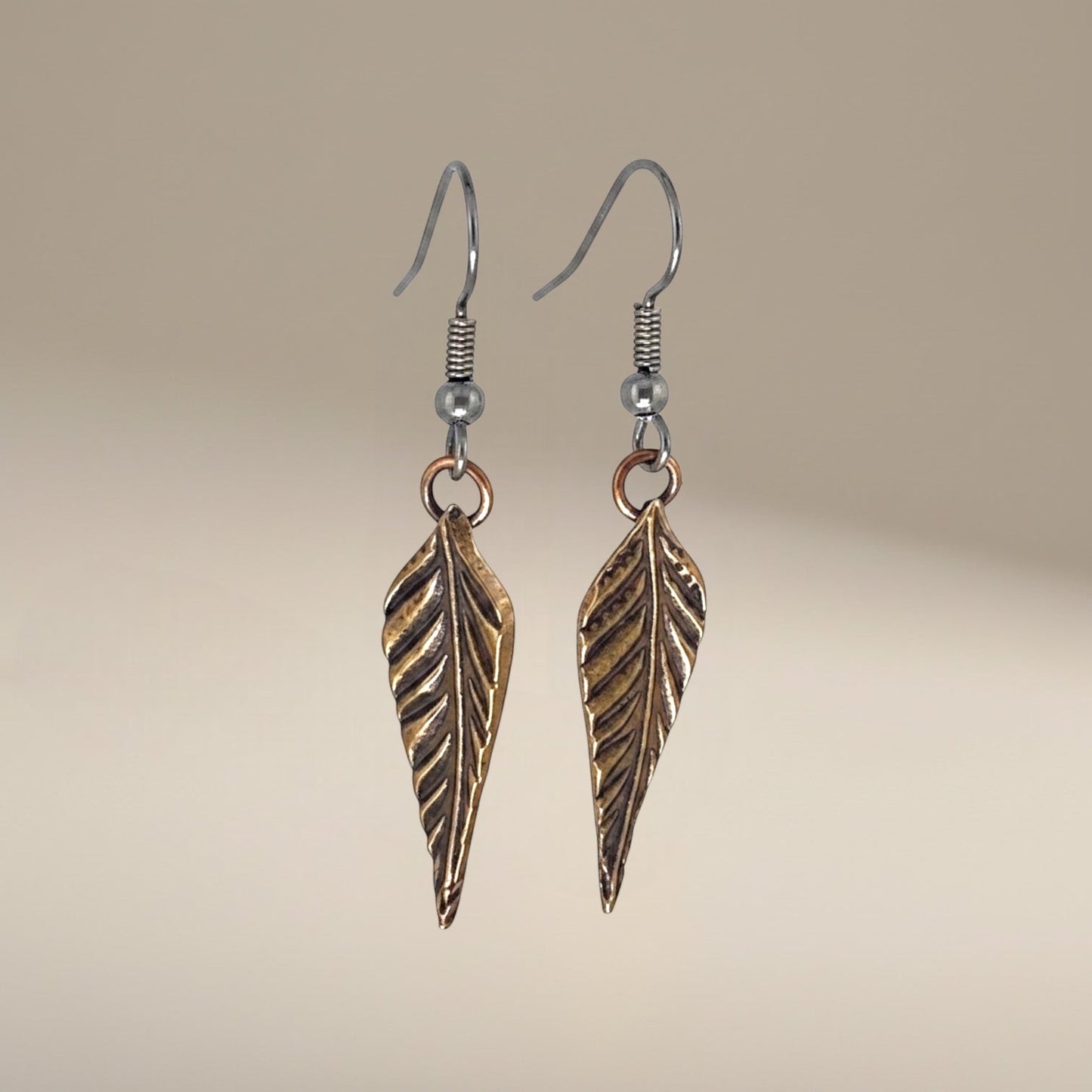 Bedrock Rose dainty rose bronze feather dangling earrings with surgical steel ear wires.