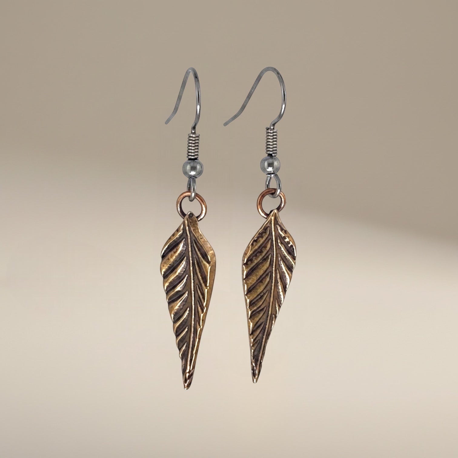 Bedrock Rose dainty rose bronze feather dangling earrings with surgical steel ear wires.