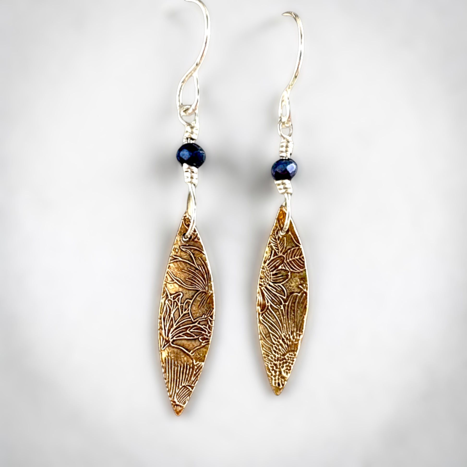 Bedrock Rose elongated rose bronze floral dangle earrings with sterling silver ear wires and dark blue beads.