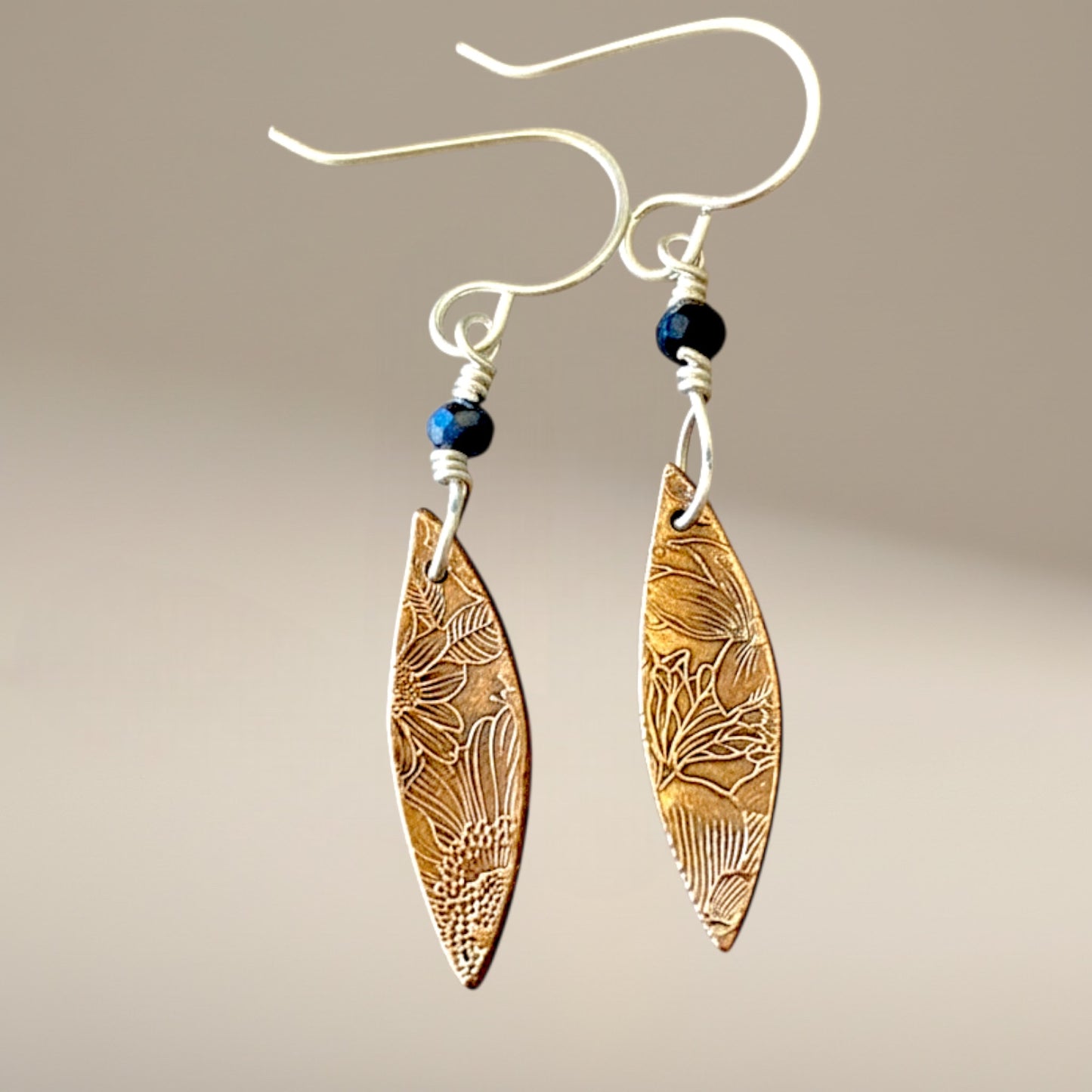 Bedrock Rose elongated oval dangle earrings with floral texture, rose bronze metal, and sterling silver ear wires.