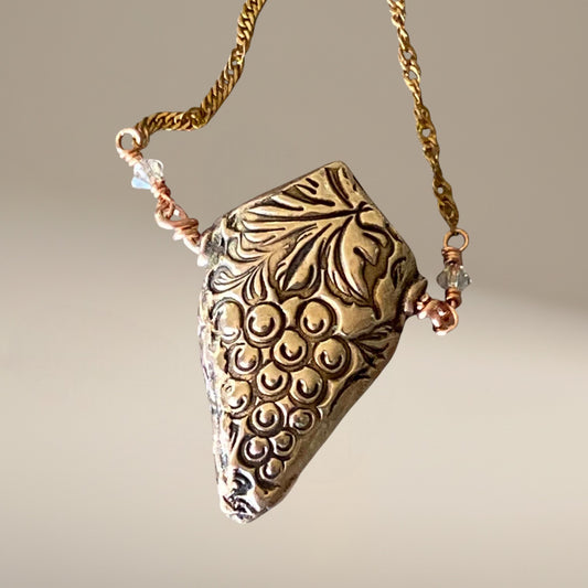 Bedrock Rose 3D grapevine pendant necklace in rose bronze with a cluster of grapes and vine details. 20" brass chain.