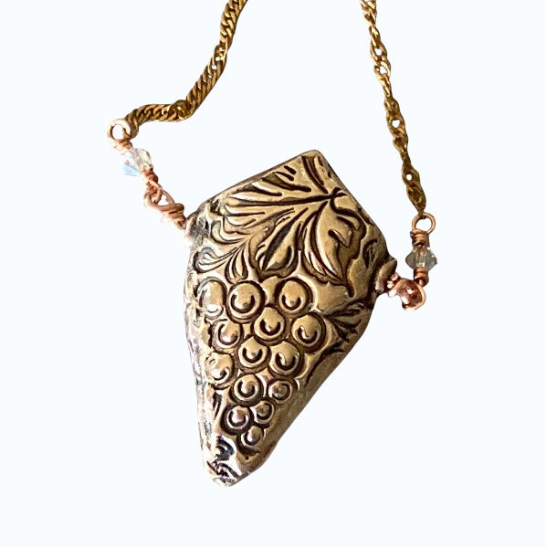 Bedrock Rose 3D grapevine pendant necklace in rose bronze with a cluster of grapes and vine detail, on a 20" brass chain.