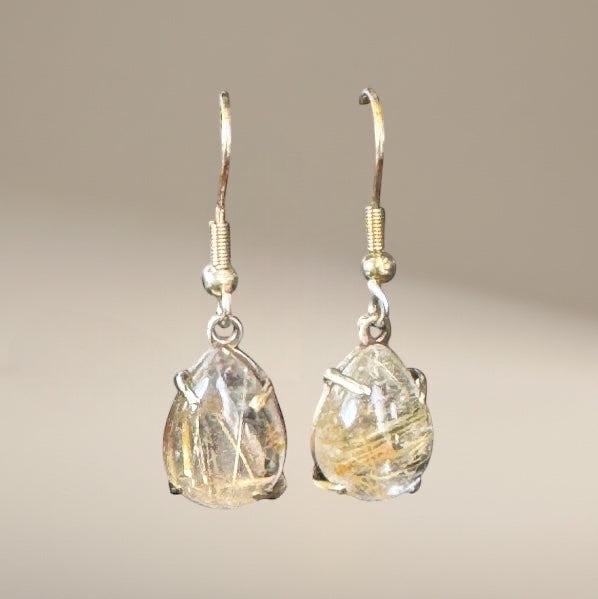 Bedrock Rose prong set pear rutilated quartz drop earrings with gold-toned metal hooks.