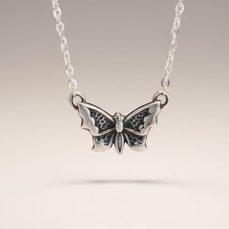 Bedrock Rose petite silver butterfly pendant necklace with intricate wing details.