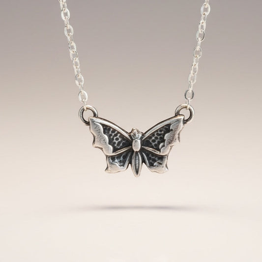 Bedrock Rose petite silver butterfly pendant necklace with intricate wing details.