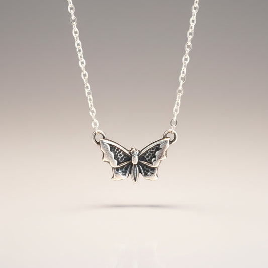Bedrock Rose petite silver butterfly pendant necklace with intricate wing details.