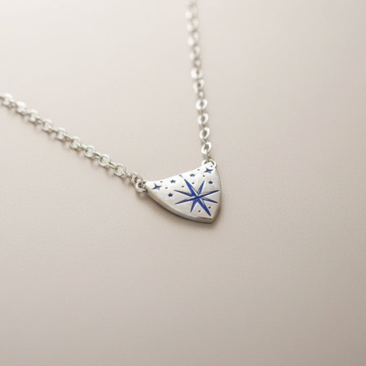 Bedrock Rose silver compass rose medallion pendant necklace with blue accents on a sterling silver cable chain.