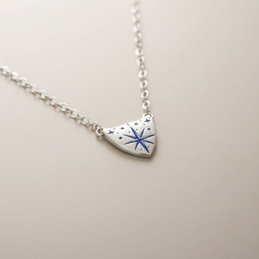 Bedrock Rose silver compass rose medallion pendant necklace with blue accents on a sterling silver cable chain.
