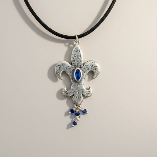 Bedrock Rose sterling silver fleur-de-lis pendant with blue marquis gemstone and dangling blue crystals.