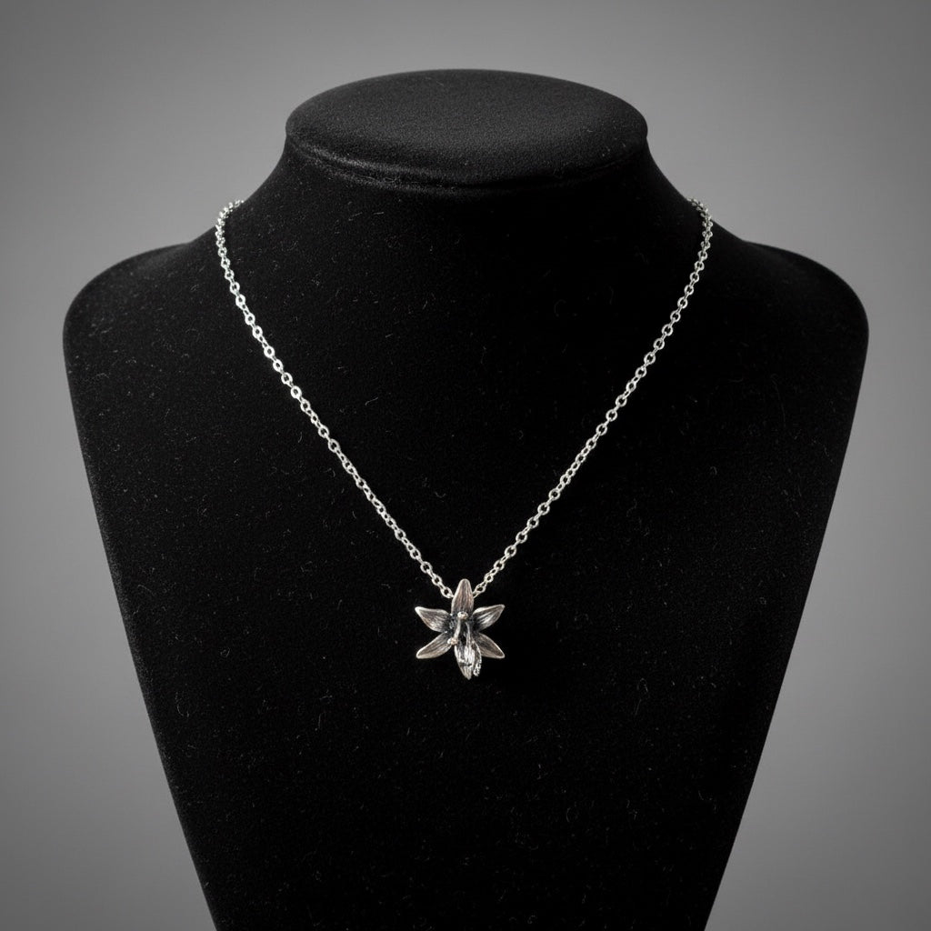 Bedrock Rose fine silver orchid pendant necklace on a delicate chain, showcasing intricate floral detail.
