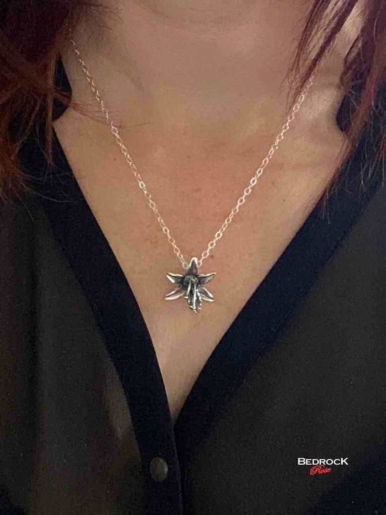 Bedrock Rose fine silver orchid pendant necklace on a delicate chain, showcasing intricate floral detail.