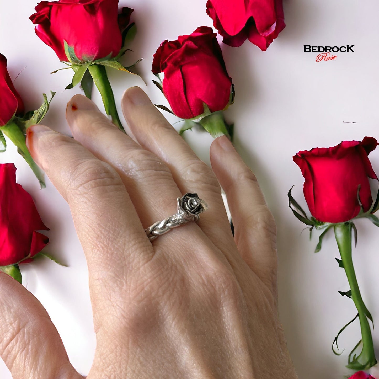Bedrock Rose hand-sculpted fine silver ring with a rosebud design on a braided band. Size 8.