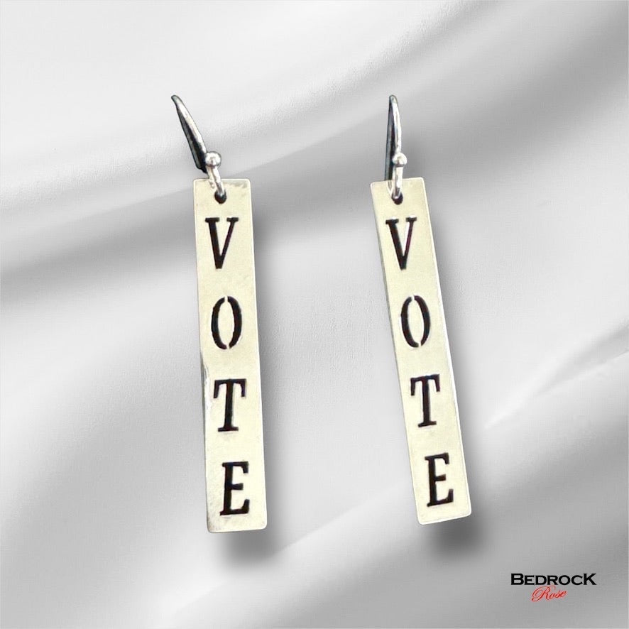 Bedrock Rose silver dangling earrings with the word VOTE in block letters. Laser-cut, gold-plated, democracy jewelry.