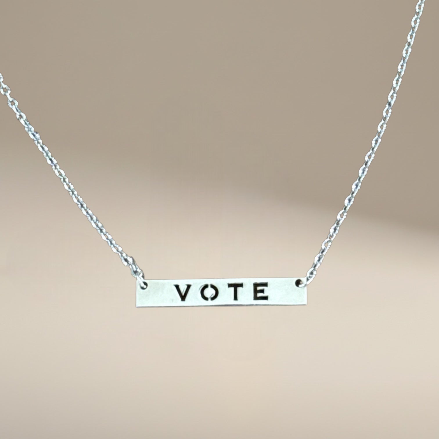 Bedrock Rose silver vote necklace with laser-cut sterling silver pendant on a hypoallergenic stainless steel chain.