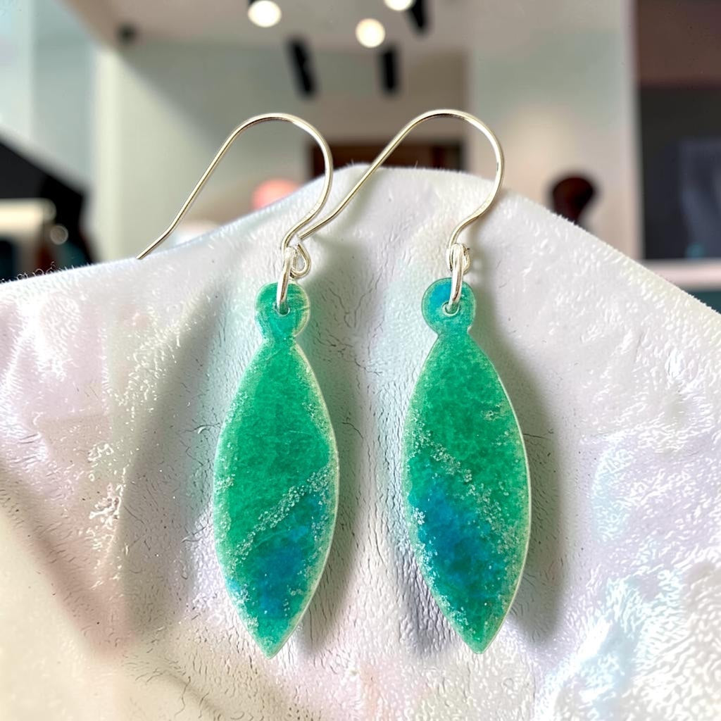 Bedrock Rose sparkly green and blue leaf-shaped dangle earrings with silver accents and surgical steel ear wires.