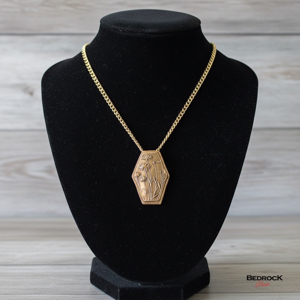 Bedrock Rose wildflower pendant in rose bronze with embossed floral design on an 18-inch brass cable chain.