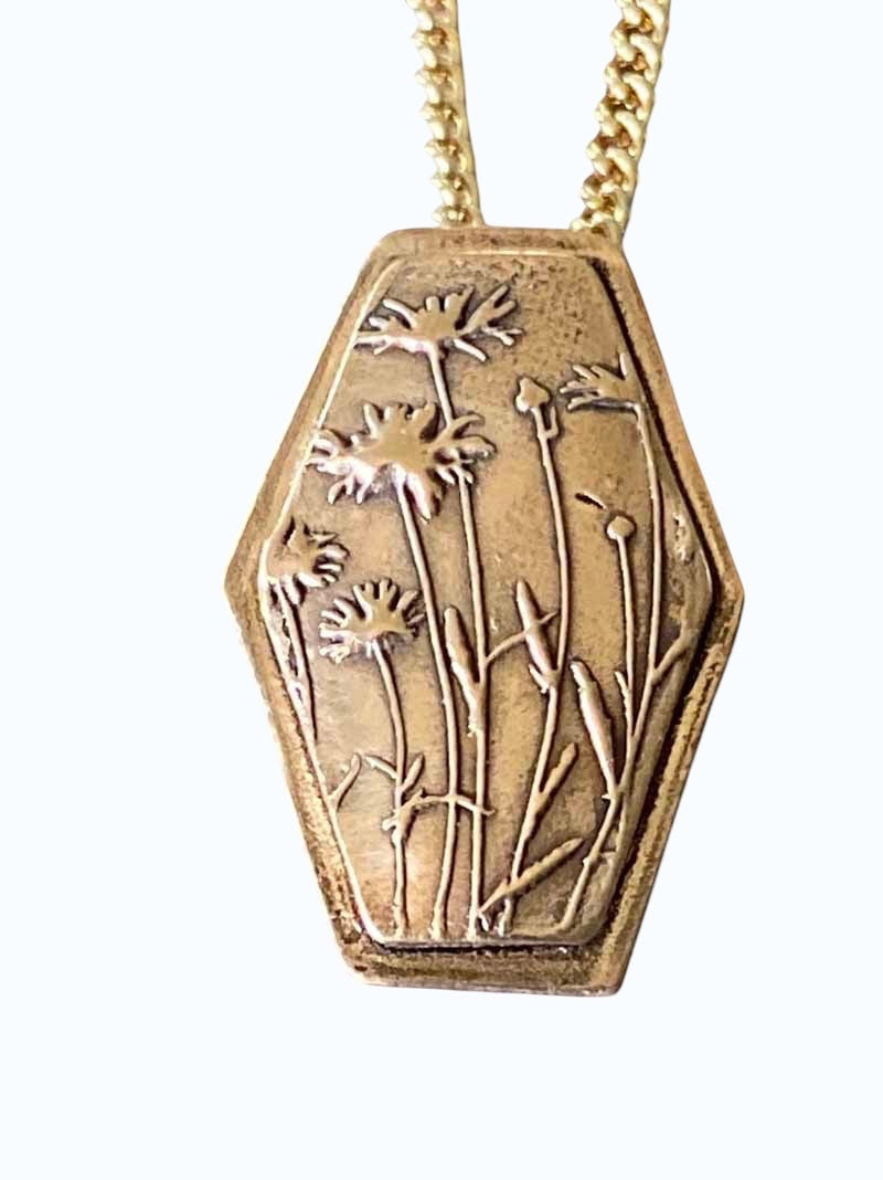 Bedrock Rose wildflower pendant in rose bronze with embossed floral design on a gold chain.