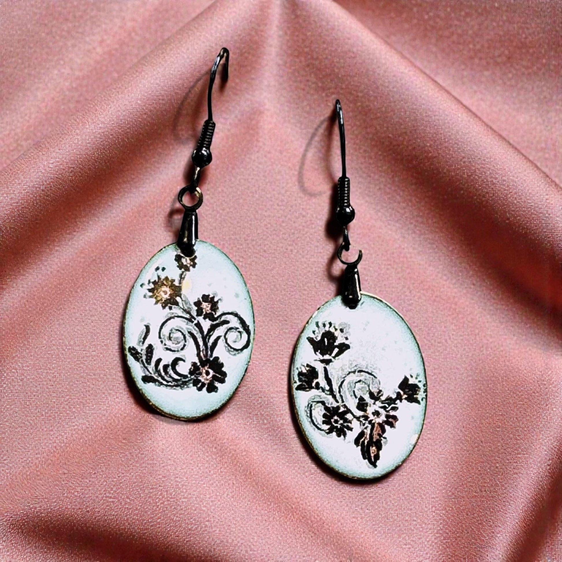 Bedrock Rose petite oval dangle earrings with black floral scroll enamel on white. Botanical design.