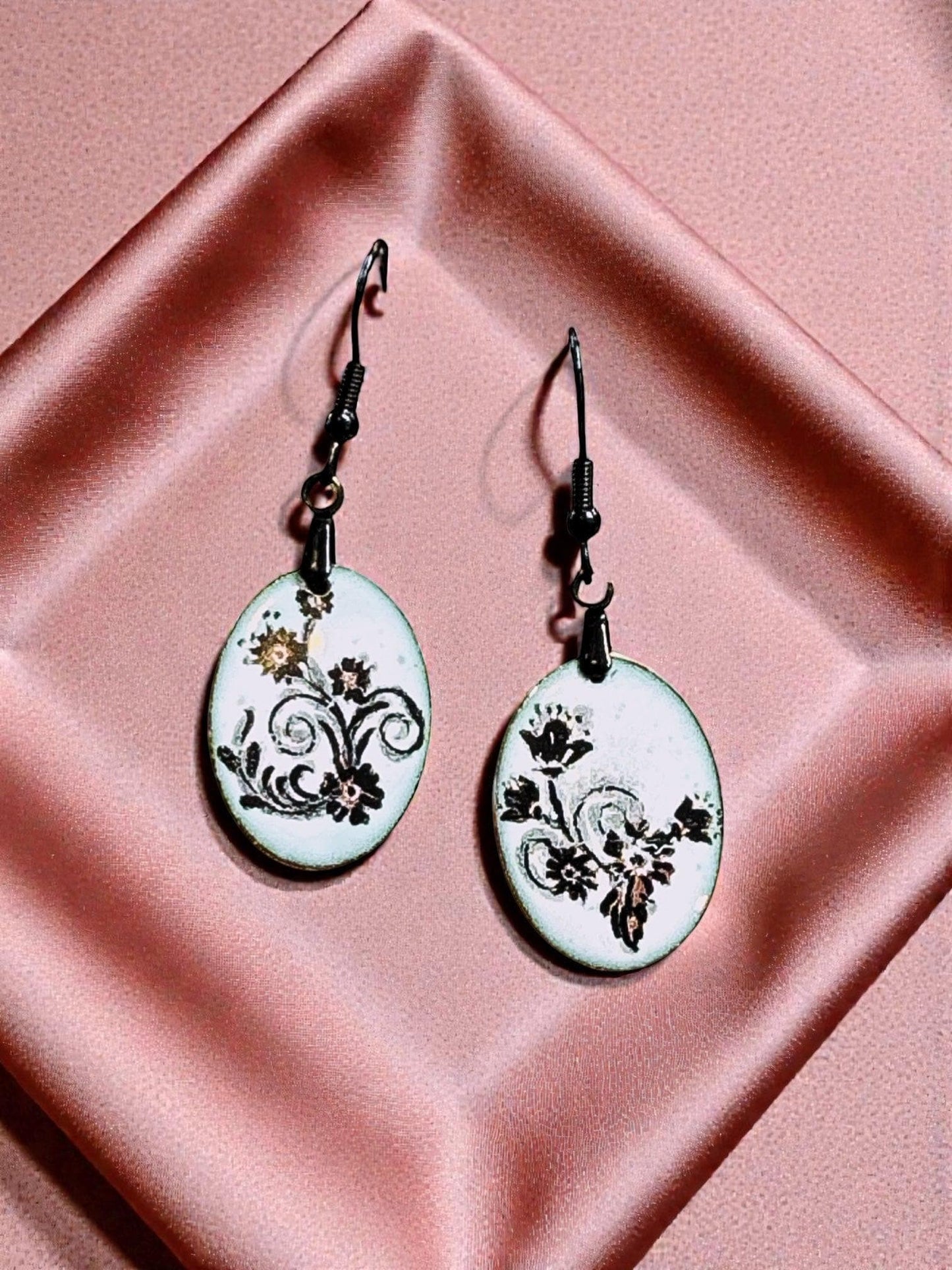Bedrock Rose petite oval dangles with black floral scrolls on white enameled glass.