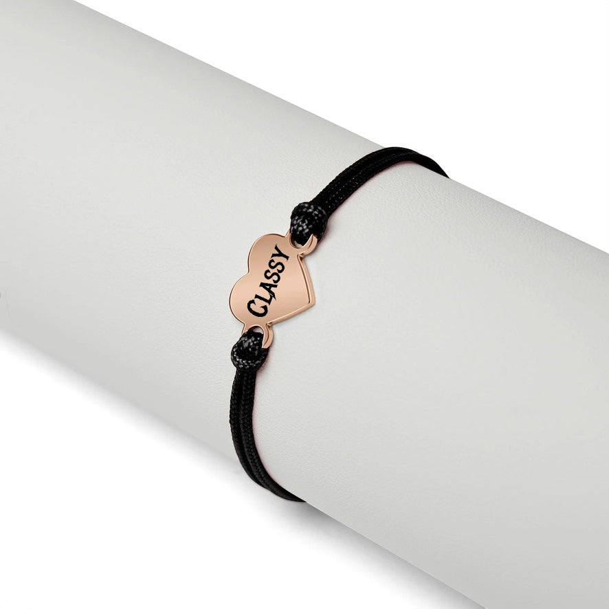 Bedrock Rose personalizable friendship bracelet with a rose gold stainless steel heart charm on a black cord.